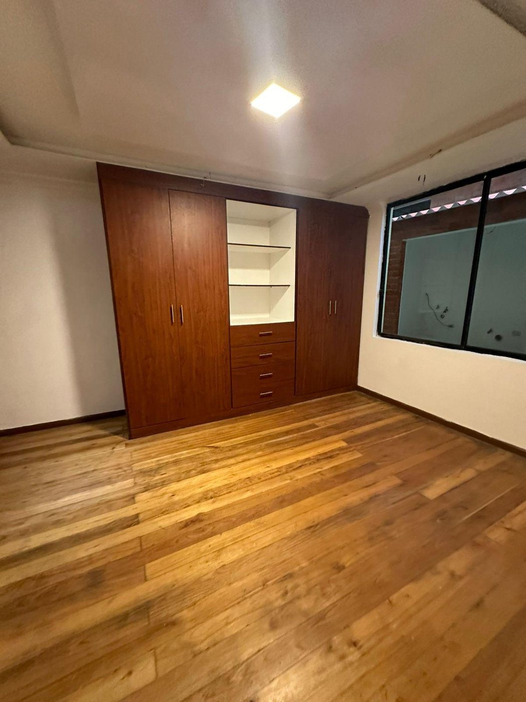 Dormitorio con clóset empotrado en departamento de casa rentera en Sayausí